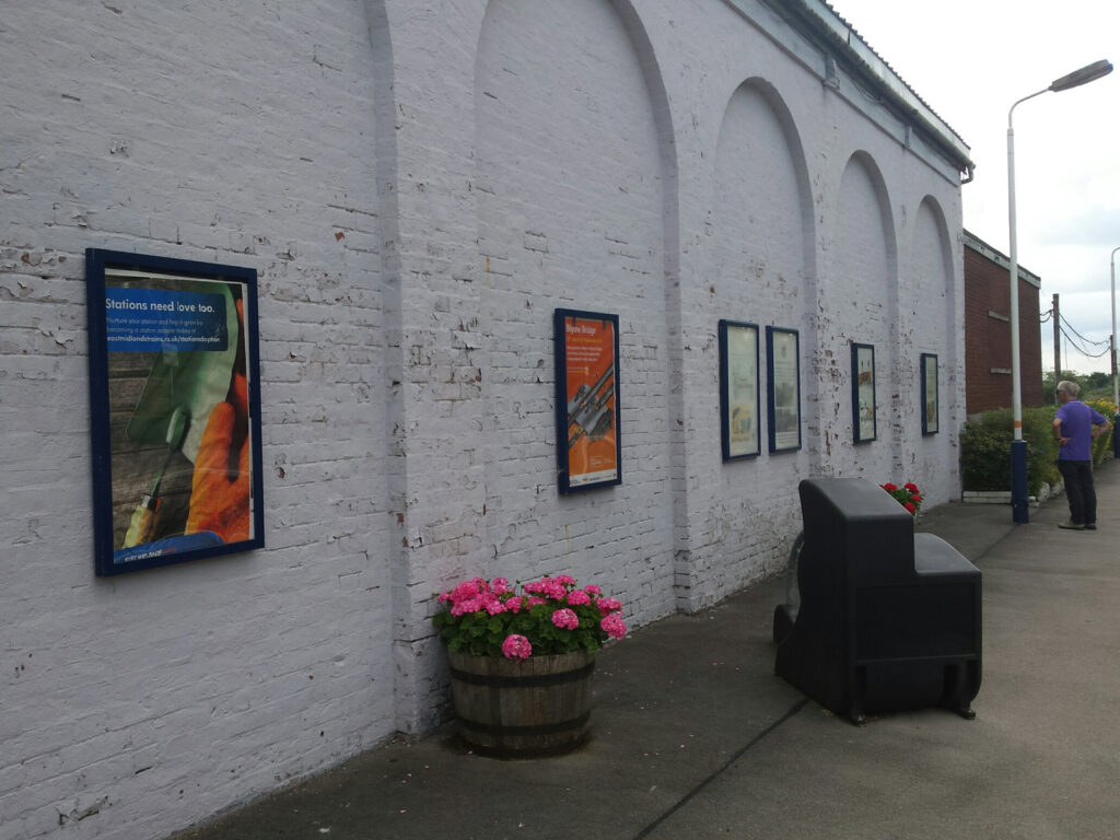 A series of posters adorn the platform of Blythe Bridge station.