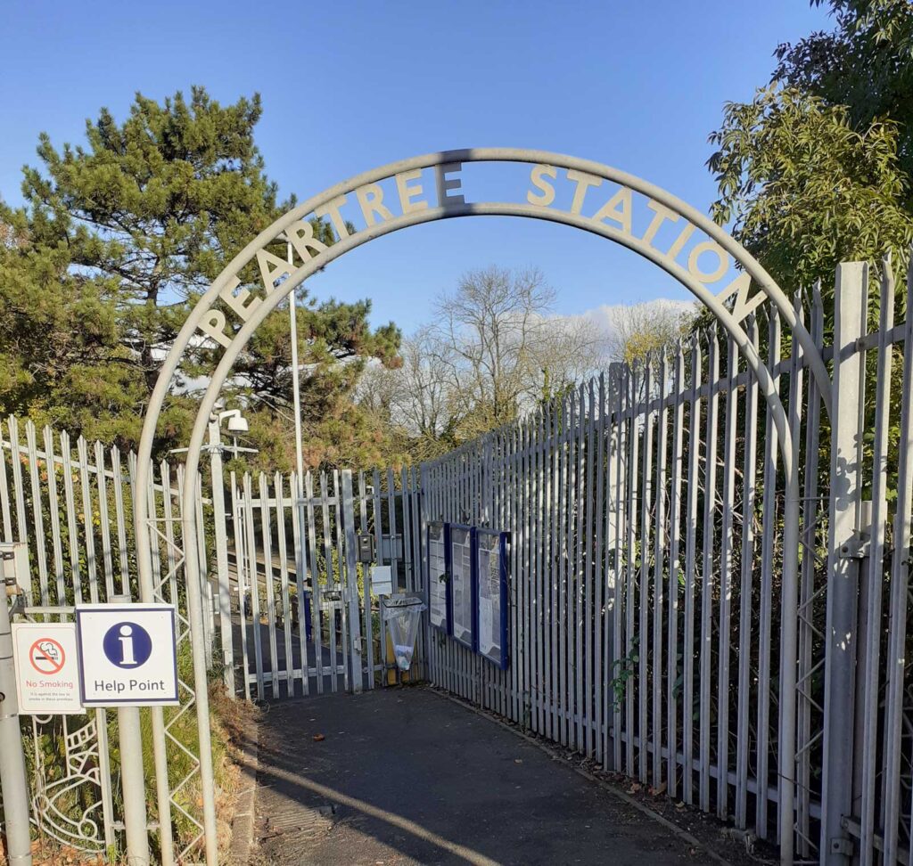 At Peartree railway station, a metal archway with the station name marks the platform entrance.