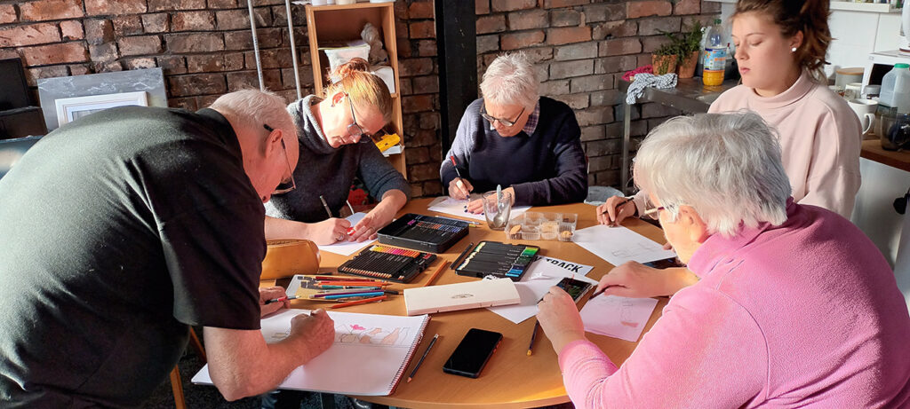 Picture showing a group of people creating drawings and artwork as part of the EMR's Route of Rememberance project.