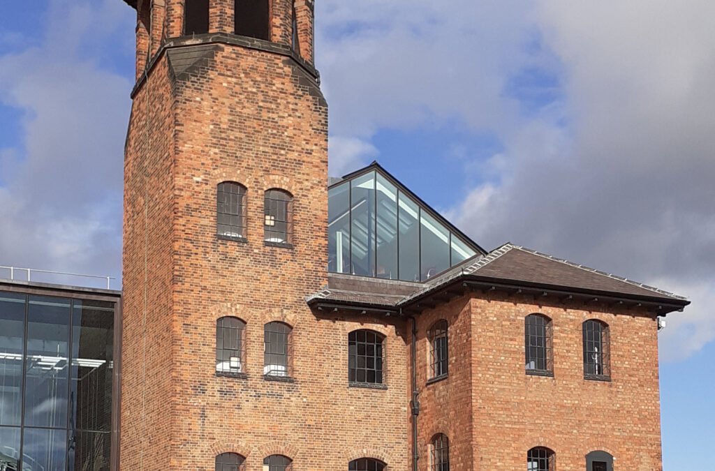 An image of the museum of making, a brick building with a glade pyramid on top.