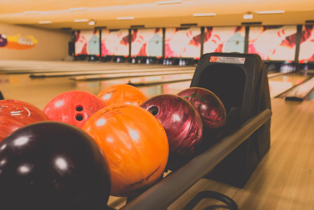 An image of bowling balls against a backdrop of bowling lanes