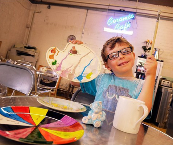 An image of a child enjoying painting ceramics at the Royal Stafford Ceramics Cafe