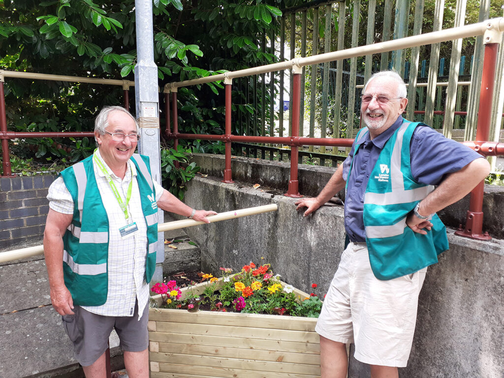 Picture of Ted and Peter (volunteers from Penkridge Gardening Club) in front of the new planters placed at the station.