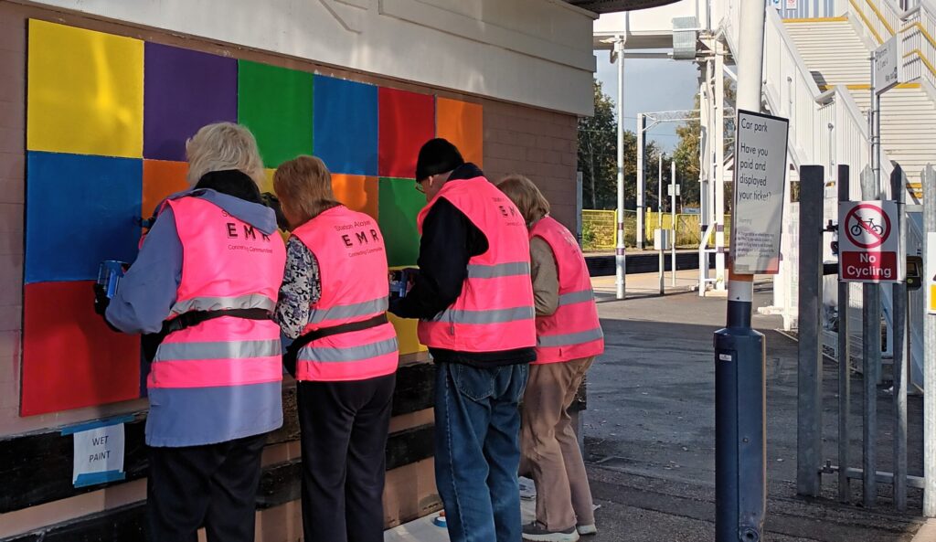 A group of volunteers working on brightening up a winter's day at Kidsgrove with a coloured wall display